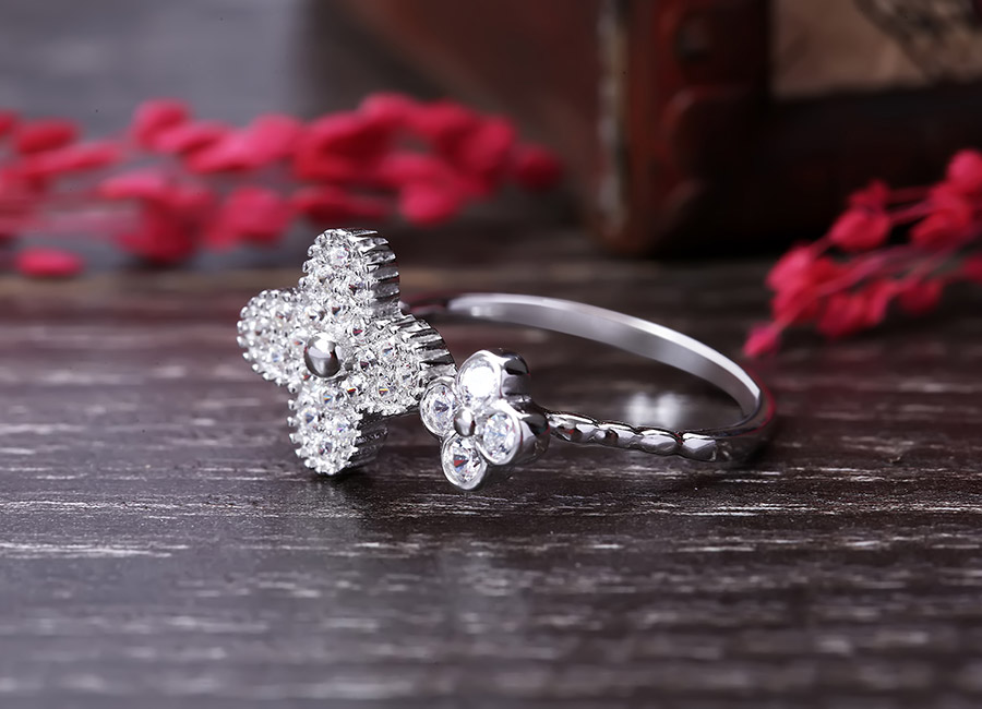 Chiếc nhẫn bạc nhỏ xinh đồng điệu với thiết kế hoa 4 cánh.