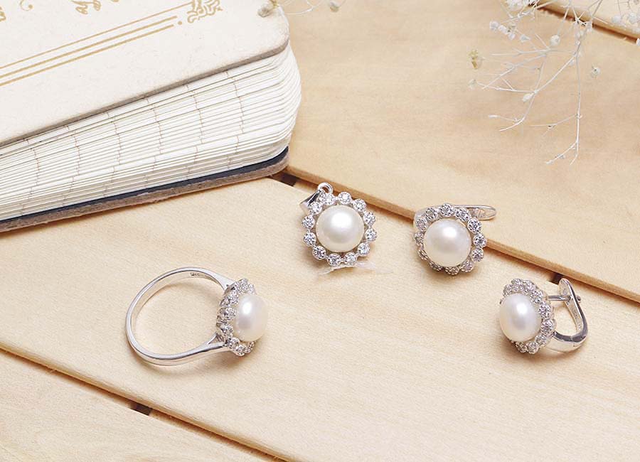 Trang sức cần phải được lựa chọn kỹ lưỡng th&igrave; ch&uacute;ng mới ph&ugrave; hợp v&agrave; gi&uacute;p bạn đẹp hơn được. Bộ trang sức bạc Tifany Pearl với thiết kế độc đ&aacute;o, rất ph&ugrave; hợp với kh&ocirc;ng gian của những bữa tiệc sang trọng.  ĐẶC ĐIỂM NỔI BẬT  Bộ trang sức bao gồm một nhẫn, đ&ocirc;i b&ocirc;ng tai v&agrave; một d&acirc;y chuyền bạc gắn ngọc trai. Ch&uacute;ng sở hữu thiết kế đồng điệu trong tạo h&igrave;nh. Tạo h&igrave;nh thiết kế của mẫu trang sức v&ocirc; c&ugrave;ng ấn tượng. Vi&ecirc;n ngọc trai nằm trung t&acirc;m, xung quanh l&agrave; những vi&ecirc;n đ&aacute; Cubic Zirconia nạm lấp l&aacute;nh. &Aacute;nh s&aacute;ng của đ&aacute; CZ v&agrave; ngọc trai thật sự v&ocirc; c&ugrave;ng ph&ugrave; hợp với m&agrave;u sắc bạc &Yacute; 925. Bạn c&oacute; thể y&ecirc;n t&acirc;m sử dụng trọn bộ nữ trang n&agrave;y mỗi khi cần sự nổi bật n&agrave;o đ&oacute;, v&iacute; dụ như tham gia c&aacute;c buổi sự kiện, bữa tiệc sang trọng.  Phụ nữ sinh ra l&agrave; để l&agrave;m đẹp v&agrave; bạn n&ecirc;n chọn mẫu trang sức n&agrave;y. Sắc s&aacute;ng của đ&aacute; v&agrave; ngọc trai lấp l&aacute;nh cuốn h&uacute;t mọi &aacute;nh nh&igrave;n. Nếu ng&oacute; lơ bộ trang sức n&agrave;y, bạn sẽ v&ocirc; c&ugrave;ng tiếc nuối đấy.